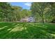 Lush backyard featuring a well-manicured lawn and mature trees, offering privacy and serenity at 2500 Little Cove Rd, Charlotte, NC 28270
