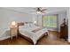Cozy bedroom with a wooden bed frame, hardwood floors, and natural light from the large window at 2500 Little Cove Rd, Charlotte, NC 28270