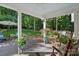Relaxing covered patio with rocking chairs, potted plants, and view of a lush backyard at 2500 Little Cove Rd, Charlotte, NC 28270