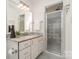 Modern bathroom featuring a glass-enclosed shower with updated fixtures, and marble countertops at 2600 Oakmeade Dr, Charlotte, NC 28270