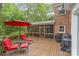 Spacious deck features red patio furniture, an umbrella, and a screened-in porch, ideal for outdoor entertaining at 2600 Oakmeade Dr, Charlotte, NC 28270