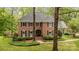Charming two-story brick home with black shutters, manicured lawn and mature trees at 2600 Oakmeade Dr, Charlotte, NC 28270
