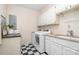 Well-equipped laundry room with white cabinets, modern appliances, and practical countertop space at 2600 Oakmeade Dr, Charlotte, NC 28270