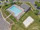 Aerial view of a community pool, clubhouse, volleyball court, and surrounding green space at 3127 Ocalle Ln, Indian Land, SC 29707