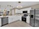 Modern kitchen featuring white cabinets, stainless steel appliances, and stylish lighting at 3127 Ocalle Ln, Indian Land, SC 29707