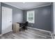 Bedroom features hardwood floors, modern gray walls and trim, and a window with a yard view at 3219 Spring Valley Dr, Gastonia, NC 28052