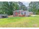 A charming brick home with a well-maintained lawn and a wooden fence at 3219 Spring Valley Dr, Gastonia, NC 28052