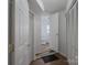 Bright hallway with tile floors leads to a half bath with a white commode and sink at 3219 Spring Valley Dr, Gastonia, NC 28052