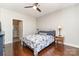 Bedroom with dark hardwood floors, ceiling fan, ensuite bathroom, and neutral paint at 333 W Trade St # 805, Charlotte, NC 28202