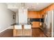 Modern kitchen with wood cabinets, stainless steel appliances, and granite countertop island at 333 W Trade St # 805, Charlotte, NC 28202
