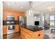 Bright kitchen featuring stainless steel appliances, a black tile backsplash, and an island at 333 W Trade St # 805, Charlotte, NC 28202