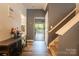 Hallway featuring neutral paint, carpeted stairs, and a view to the living room through an arched doorway at 3412 Summerfield Ridge Ln, Matthews, NC 28105