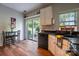 Eat-in kitchen featuring a sliding glass door to backyard, black appliances, and wood-look floors at 3412 Summerfield Ridge Ln, Matthews, NC 28105