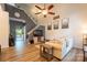 Bright living room with vaulted ceiling, wood floors, ceiling fan, and open staircase at 3412 Summerfield Ridge Ln, Matthews, NC 28105