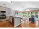 Open-concept kitchen flows into a cozy living room with hardwood floors and abundant windows at 3744 Leela Palace Way, Fort Mill, SC 29708