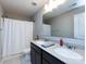 Well-lit bathroom featuring double sinks, a large mirror, and a shower with white curtain at 4012 Martele Dr, Mint Hill, NC 28227