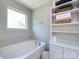 Bright bathroom featuring a soaking tub, linen closet, and a large window at 4012 Martele Dr, Mint Hill, NC 28227