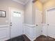 Bright entryway with hardwood floors, wainscoting, and a white front door, creating a clean and welcoming space at 4012 Martele Dr, Mint Hill, NC 28227