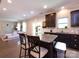Open kitchen features dark cabinetry, granite counters, a center island with seating, and flows into the living area at 4012 Martele Dr, Mint Hill, NC 28227