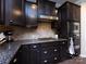 This kitchen boasts stainless appliances, dark wood cabinetry, granite counters, and a mosaic tile backsplash at 4012 Martele Dr, Mint Hill, NC 28227
