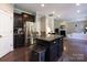 This kitchen boasts stainless appliances, dark wood cabinetry, granite counters, and overlooks the living area at 4012 Martele Dr, Mint Hill, NC 28227