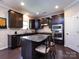 Well-appointed kitchen with dark cabinets, granite countertops, a center island, and stainless steel appliances at 4012 Martele Dr, Mint Hill, NC 28227