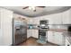 Bright kitchen with stainless steel appliances, white cabinetry, and stylish wood flooring at 5057 Sedgefield Dr, Lancaster, SC 29720