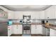 Well-lit kitchen featuring white cabinets, stainless steel appliances, and wood-look flooring at 5057 Sedgefield Dr, Lancaster, SC 29720
