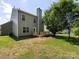 Exterior backyard view of a house, showcasing a wooden deck, trees, and a grass area, perfect for outdoor activities at 521 Ellingsworth Ln, Charlotte, NC 28214