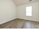 Bright bedroom with wood-look floors, a window providing natural light, and neutral walls for a calming atmosphere at 521 Ellingsworth Ln, Charlotte, NC 28214