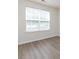 Neutral bedroom showcasing a large window with natural light and wood-style flooring at 521 Ellingsworth Ln, Charlotte, NC 28214