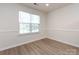 Neutral bedroom showcasing a large window with natural light and wood-style flooring at 521 Ellingsworth Ln, Charlotte, NC 28214