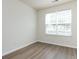Bedroom showcasing a large window with natural light and wood-style flooring at 521 Ellingsworth Ln, Charlotte, NC 28214