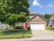 Charming two-story home featuring a stone-accented facade, red door, and a well-manicured front yard at 521 Ellingsworth Ln, Charlotte, NC 28214