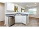 Bright kitchen featuring white cabinets, stainless steel dishwasher, and open layout at 521 Ellingsworth Ln, Charlotte, NC 28214