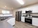 Well-equipped kitchen boasts stainless steel appliances, gray countertops, ample cabinet space, and a view to the dining area at 521 Ellingsworth Ln, Charlotte, NC 28214