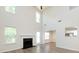 Bright living room featuring soaring ceilings, many windows, a decorative fireplace, and views into the dining room and kitchen at 521 Ellingsworth Ln, Charlotte, NC 28214