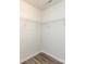 Walk-in closet with white wire shelving and neutral walls complemented by wood-look flooring, maximizing storage and style at 521 Ellingsworth Ln, Charlotte, NC 28214