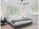 Cozy bedroom with large windows, ceiling fan, plush rug, and comfortable queen-sized bed at 5219 Farmbrook Dr, Charlotte, NC 28210