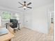 Bright bedroom features hardwood flooring, ceiling fan, natural light and functional workspace at 5219 Farmbrook Dr, Charlotte, NC 28210