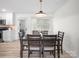 Dining room with modern table set for six, contemporary light fixture, and easy access to kitchen appliances at 5219 Farmbrook Dr, Charlotte, NC 28210