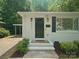 Welcoming front entrance with a classic black door, brick facade, and manicured landscaping enhancing curb appeal at 5219 Farmbrook Dr, Charlotte, NC 28210