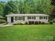 Charming white brick home with a well-manicured lawn and lush landscaping creating an inviting curb appeal at 5219 Farmbrook Dr, Charlotte, NC 28210