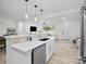 Open-concept kitchen with stainless steel appliances, breakfast bar, modern lighting and views into the living room at 5219 Farmbrook Dr, Charlotte, NC 28210