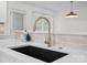 Close-up of a modern kitchen sink featuring a matte black basin, quartz countertop, and stylish gold faucet at 5219 Farmbrook Dr, Charlotte, NC 28210