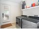 Charming laundry area with white brick, modern appliances, and a convenient storage shelf at 5219 Farmbrook Dr, Charlotte, NC 28210