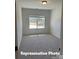 Cozy bedroom showcasing neutral carpeting, a large window, and plenty of natural light at 6209 Busch Way, Midland, NC 28107