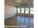 Spacious living room featuring wood-look floors, recessed lighting, and large windows for ample natural light at 6209 Busch Way, Midland, NC 28107