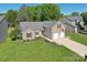 Aerial view of a brick home with a two-car garage, manicured lawn, and mature trees at 6724 Long Nook Ln, Indian Trail, NC 28079