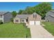 Aerial view of a brick home with a two-car garage, manicured lawn, and mature trees at 6724 Long Nook Ln, Indian Trail, NC 28079
